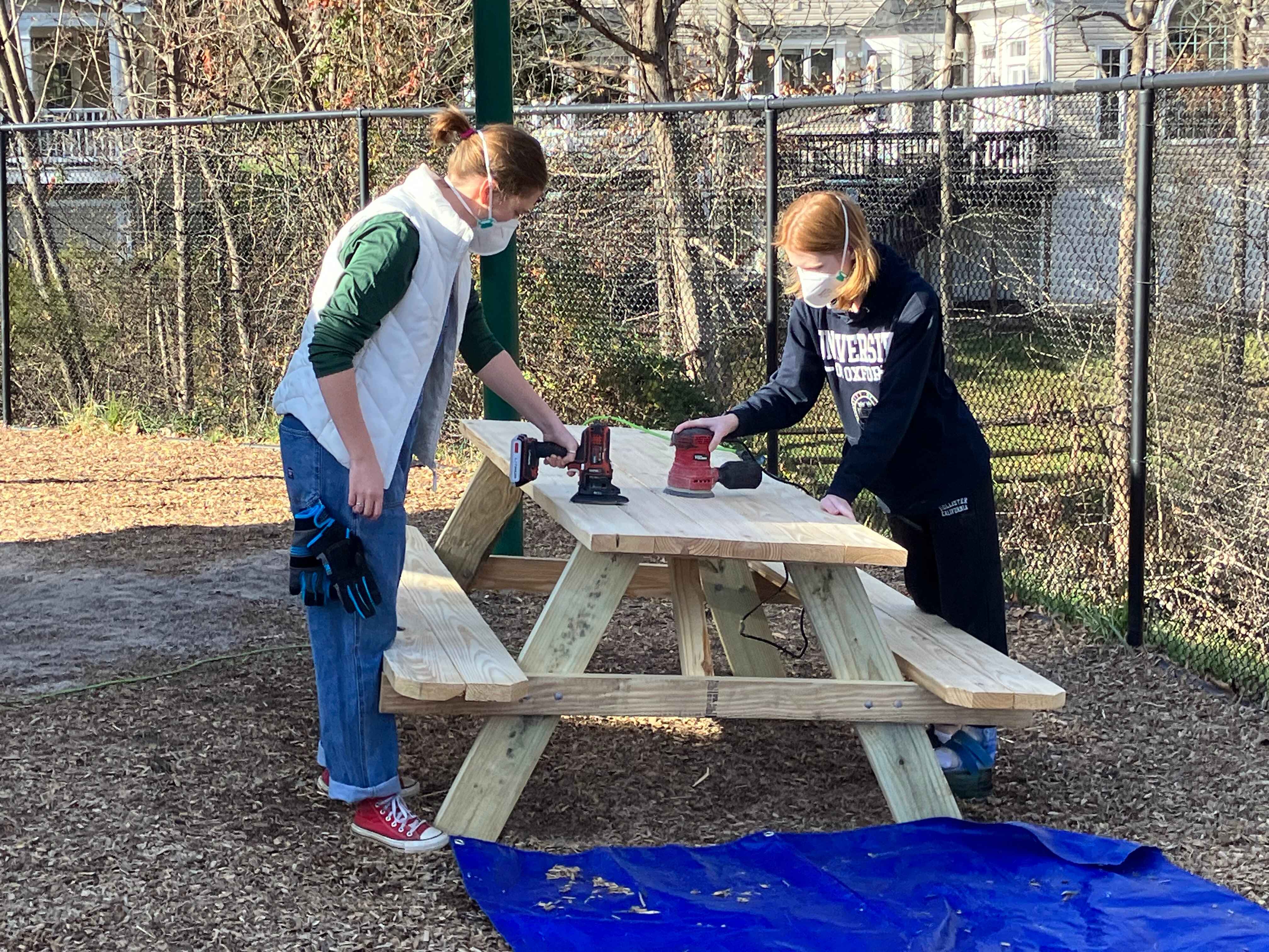 Volunteers sanding down the table tops